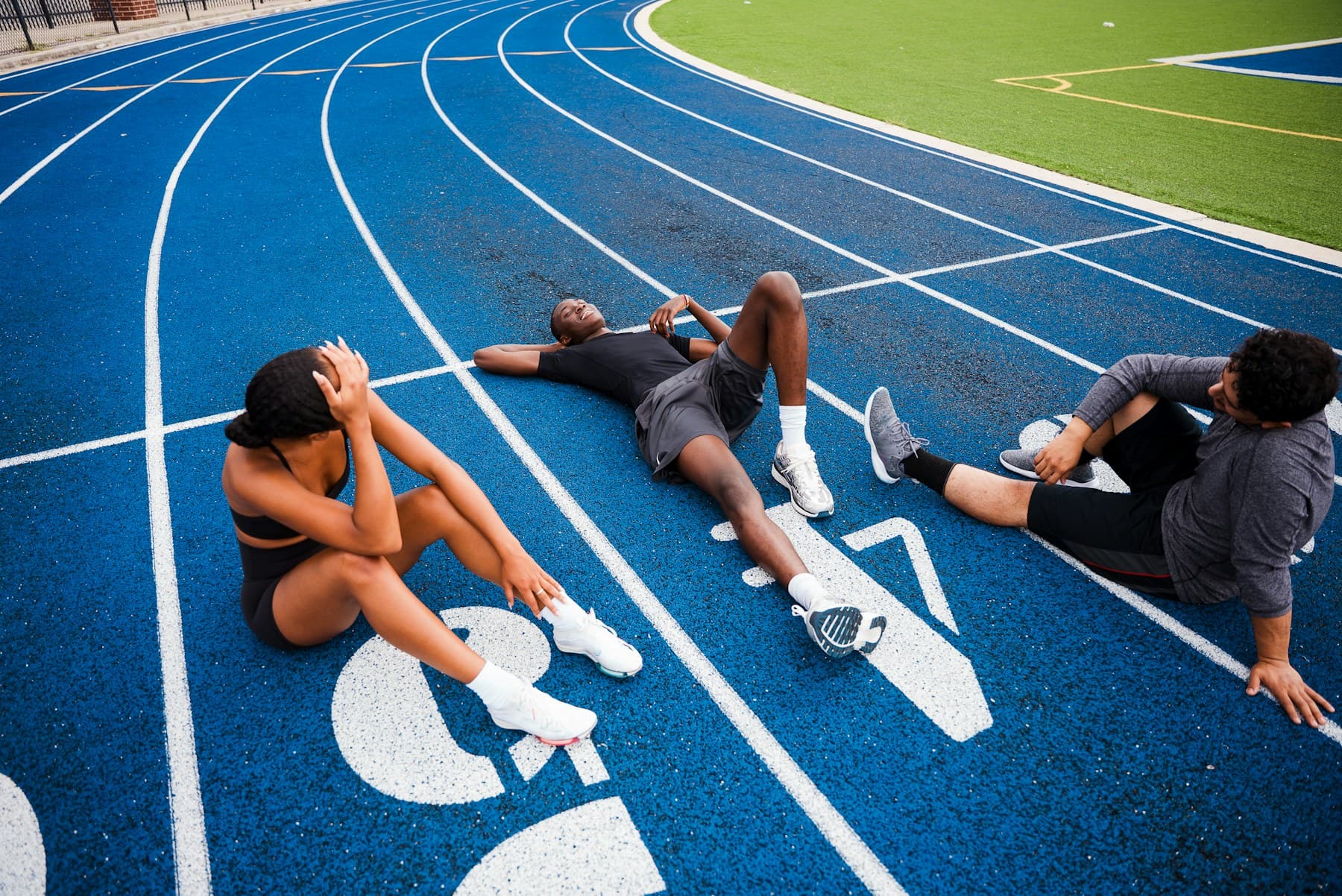 Atletas descansando después de entrenar en una pista azul